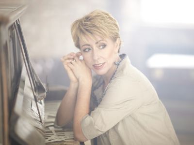 Nikki Iles sat down with elbows resting on a piano